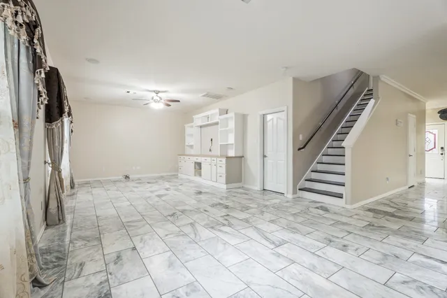 a view of a hallway with staircase and white walls