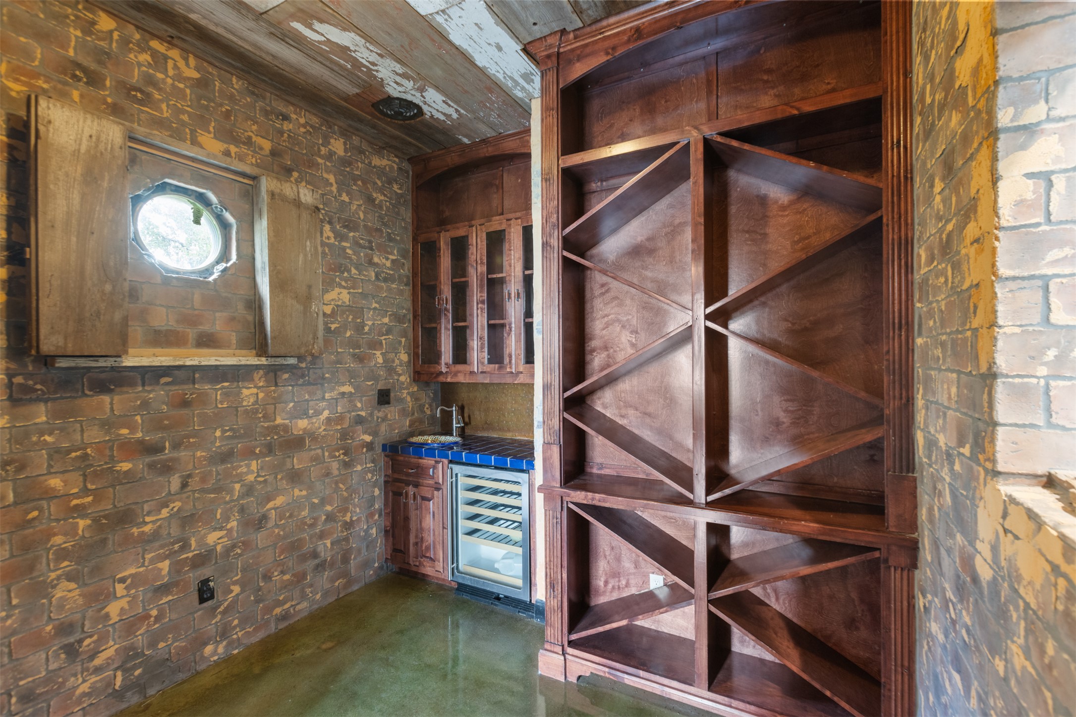 3149 Byrd Ranch Road Johnson City, TX 78636 - Photo 11 of 39 Wine area featuring brick wall, concrete floors, and beverage cooler