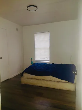 a bed sitting in a bedroom next to a window