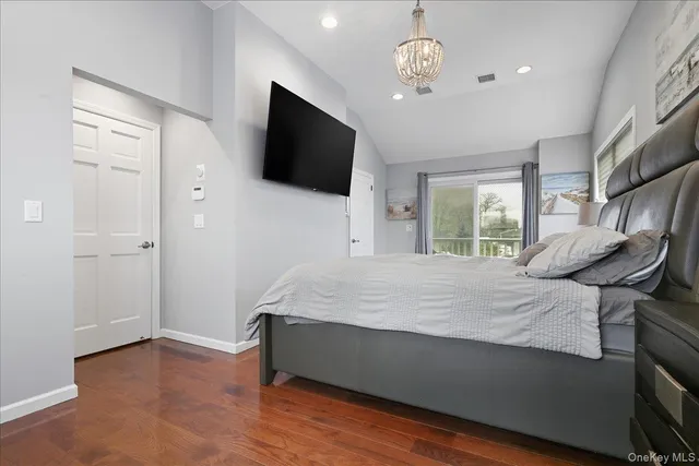 a spacious bedroom with a bed and a flat screen tv