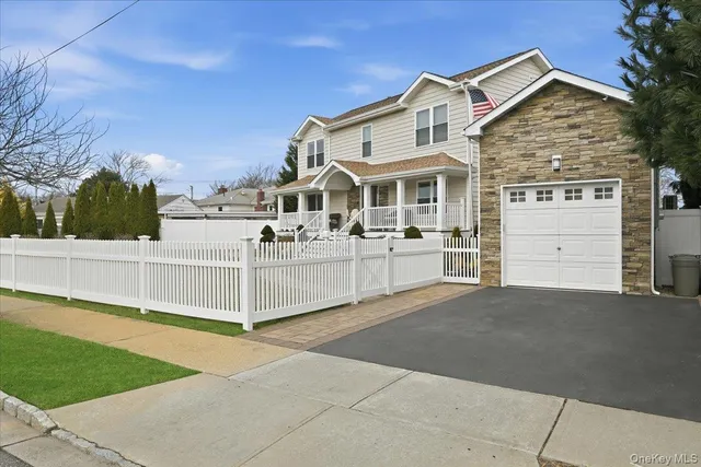 a view of a white house with a yard and fence