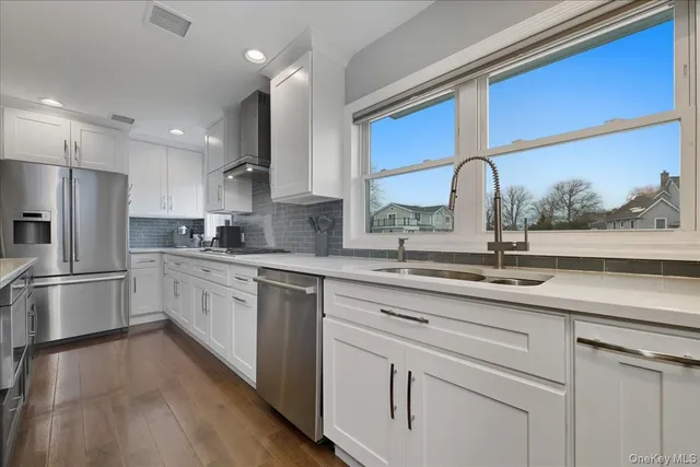 a kitchen with a sink cabinets stainless steel appliances and a counter top space