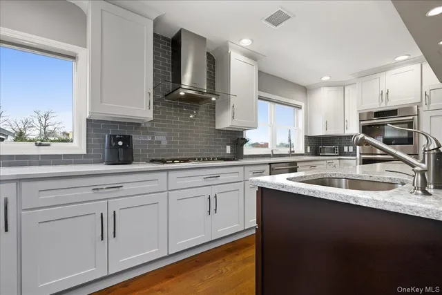 a kitchen with granite countertop a sink stainless steel appliances and cabinets