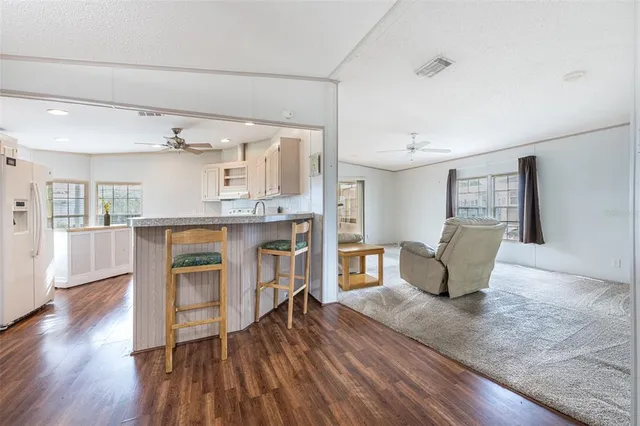 a living room with furniture and a kitchen view