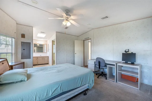 a bedroom with a large bed and a chandelier