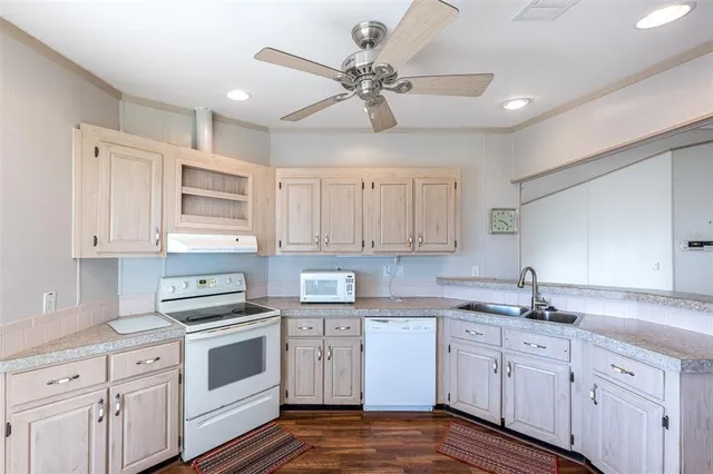 a kitchen with cabinets stainless steel appliances a sink and a window