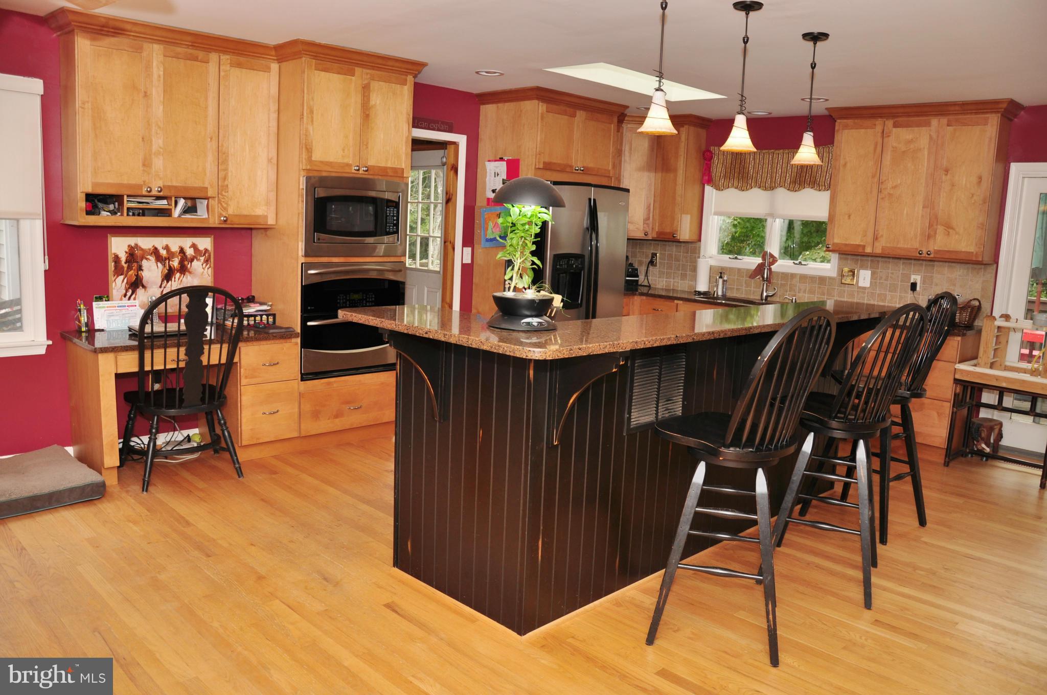 18608 Upper Beckleysville Road Hampstead, MD 21074 - Photo 12 of 29 a kitchen with stainless steel appliances kitchen island granite countertop a table chairs and a stove