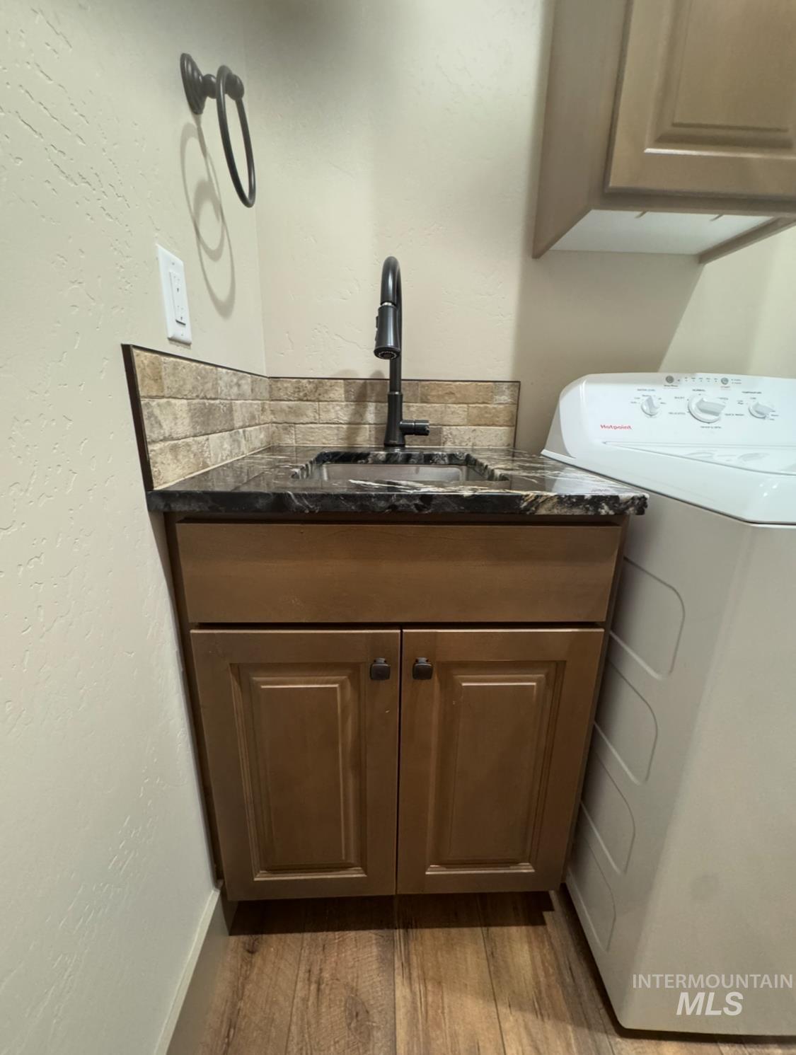 1346 Zephlyn Street Twin Falls, ID 83301 - Photo 11 of 34 Washroom with washer / dryer, a textured wall, light wood-style flooring, and cabinet space
