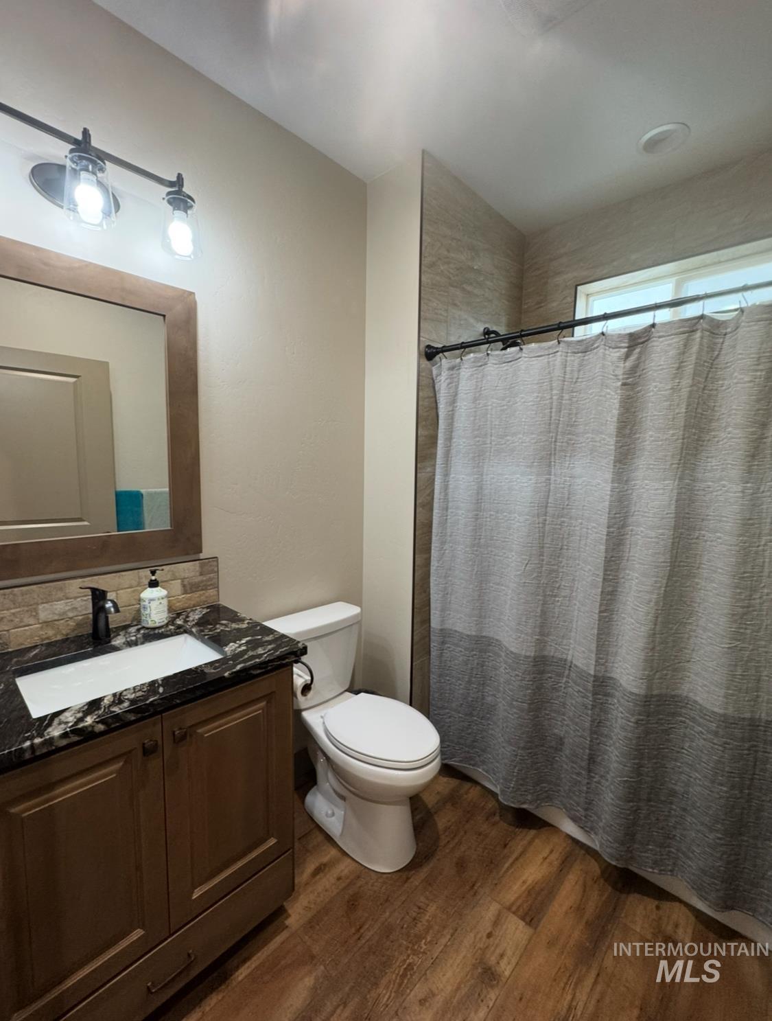 1346 Zephlyn Street Twin Falls, ID 83301 - Photo 26 of 34 Full bathroom featuring a shower with curtain, vanity, dark wood-style floors, and backsplash