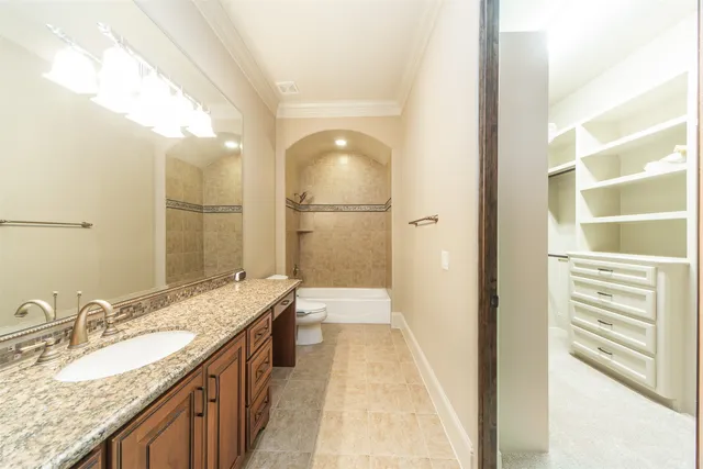 a bathroom with a granite countertop double vanity sink and mirror
