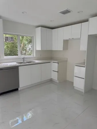 a kitchen with white cabinets and white appliances
