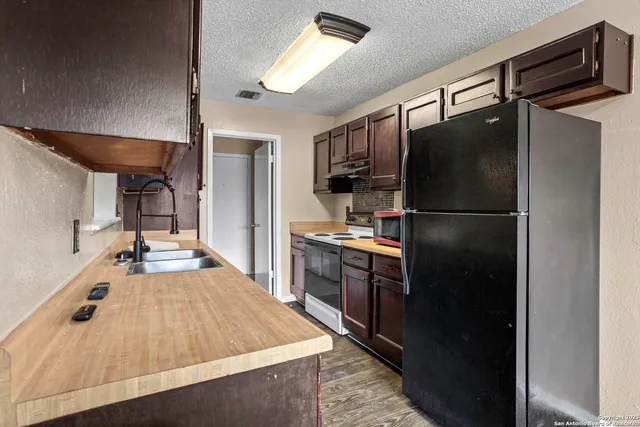 a kitchen with kitchen island a counter top space stainless steel appliances and cabinets