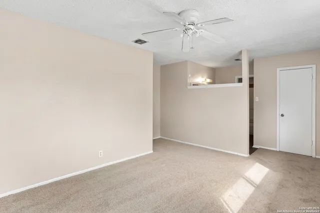 an empty room with a ceiling fan and a window