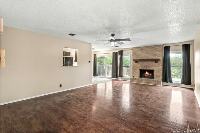 a view of an empty room with window and fire place