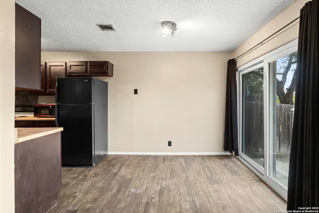 a view of a refrigerator in kitchen and wooden floor