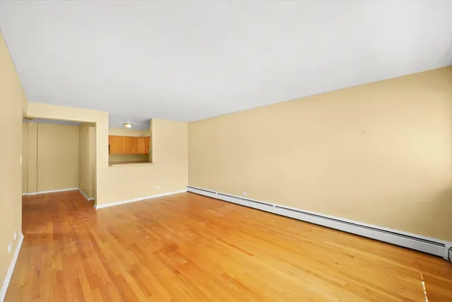 a view of empty room with wooden floor
