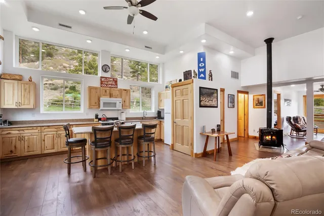 a living room with furniture kitchen view and a large window