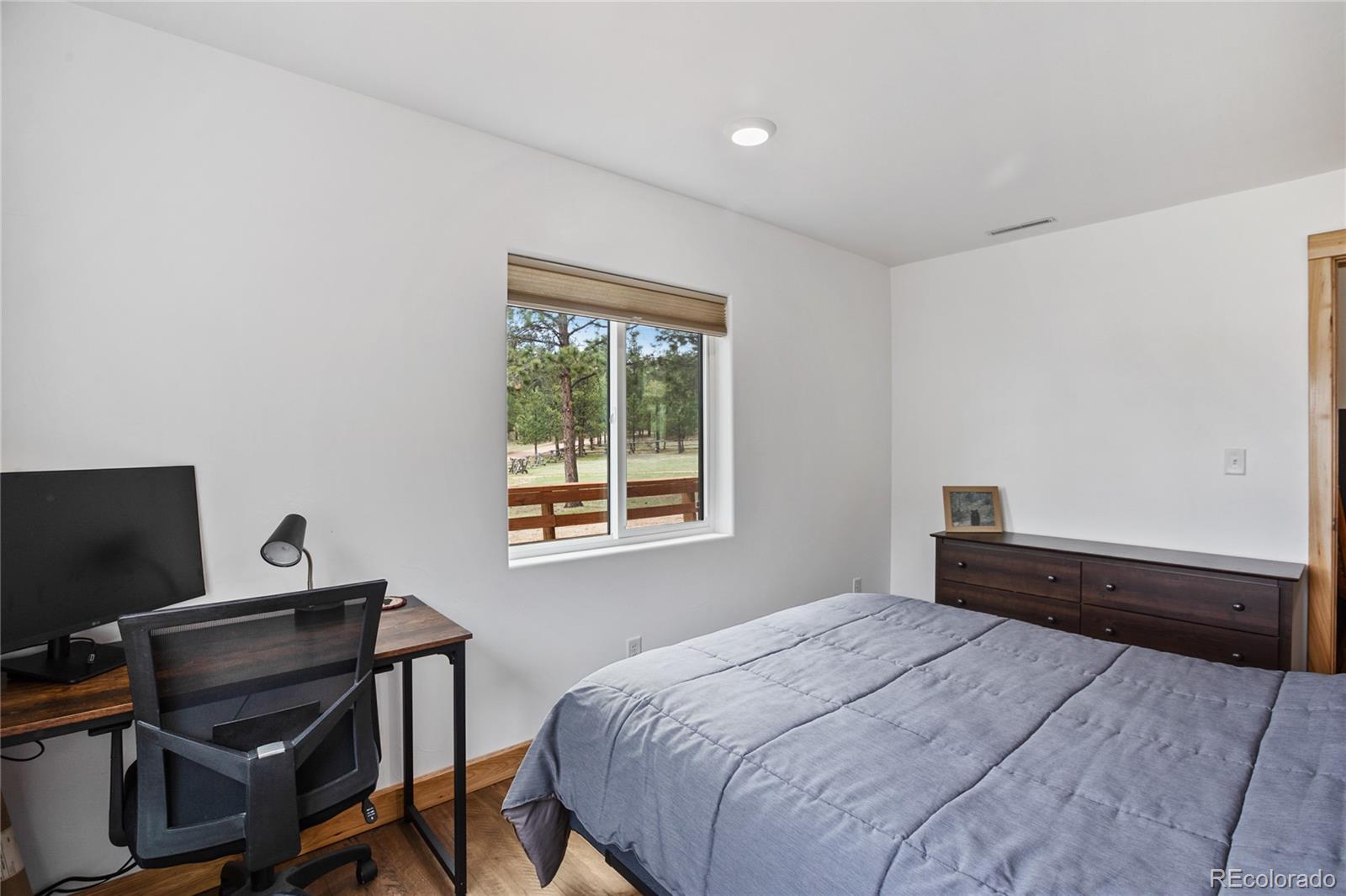 437 Langnis Road Guffey, CO 80820 - Photo 21 of 33 a bedroom with a bed table chair and a window