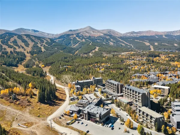 an aerial view of a house with a mountain