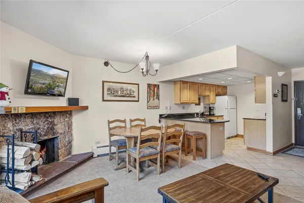 a living room with furniture a rug and kitchen view