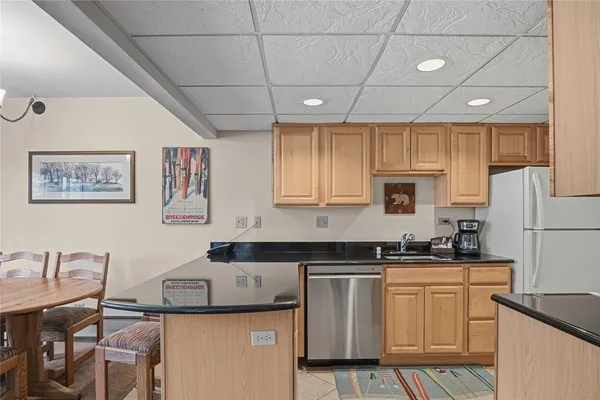 a kitchen with granite countertop a sink a stove a refrigerator cabinets and dining table