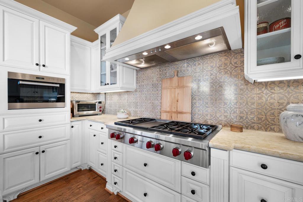 7089 Heron Circle Carlsbad, CA 92011 - Photo 17 of 58 a kitchen with white cabinets and appliances
