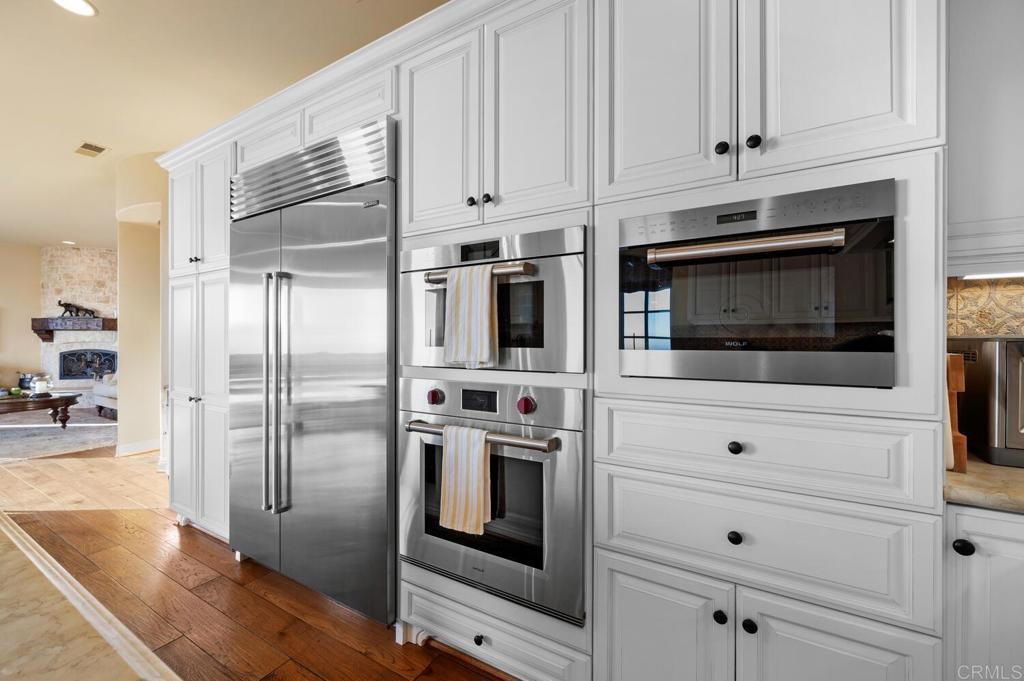 7089 Heron Circle Carlsbad, CA 92011 - Photo 18 of 58 a kitchen with stainless steel appliances white cabinets and a stove