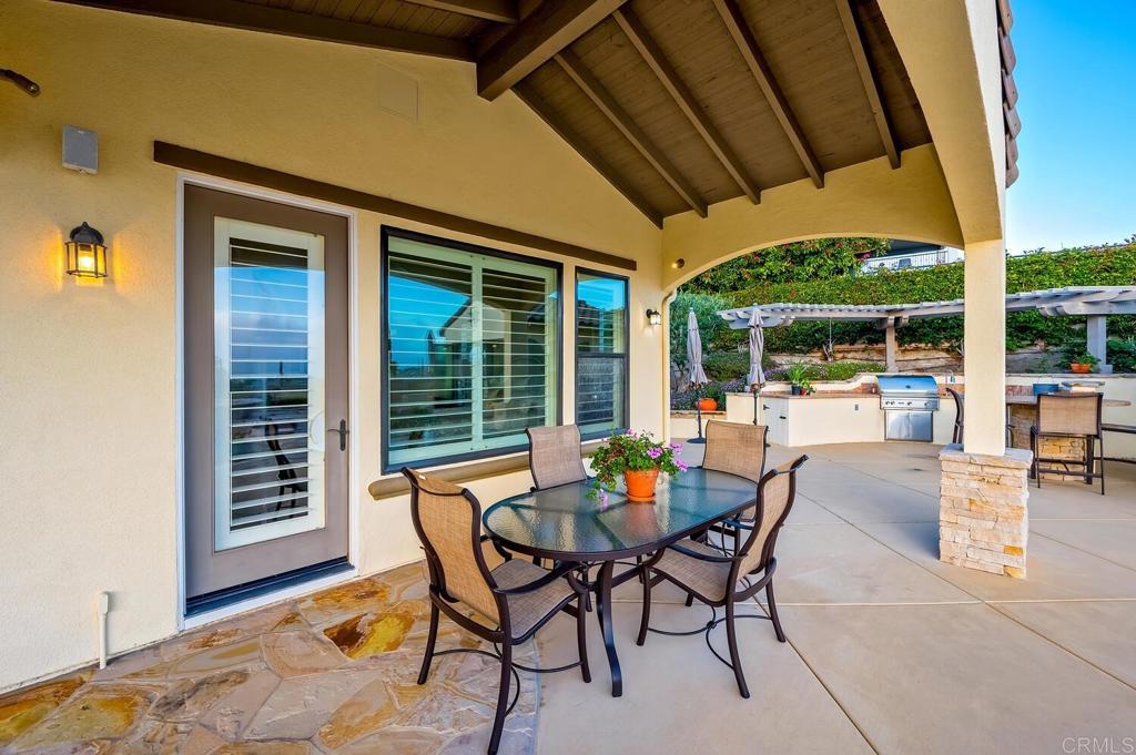 7089 Heron Circle Carlsbad, CA 92011 - Photo 58 of 58 a view of a patio with a dining table and chairs under an umbrella