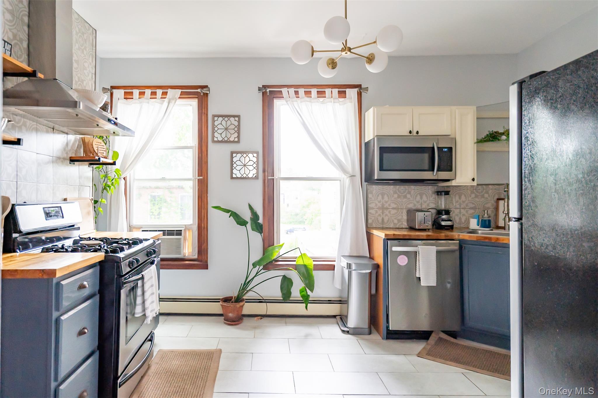175 Liberty Street Newburgh, NY 12550 - Photo 37 of 50 a kitchen with stainless steel appliances a stove a sink cabinets and a refrigerator