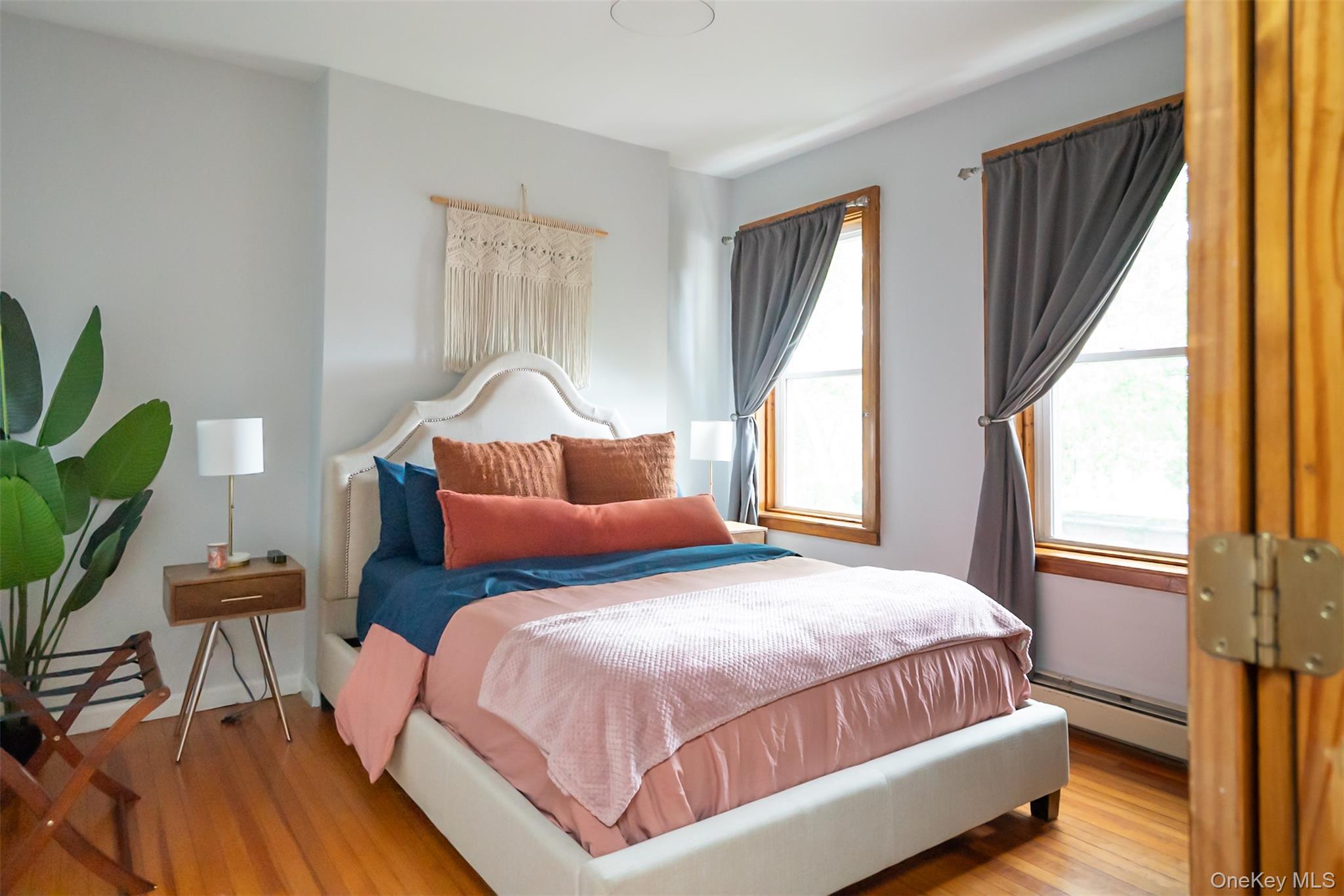 175 Liberty Street Newburgh, NY 12550 - Photo 38 of 50 a bedroom with a bed lamp and a large window with wooden floor