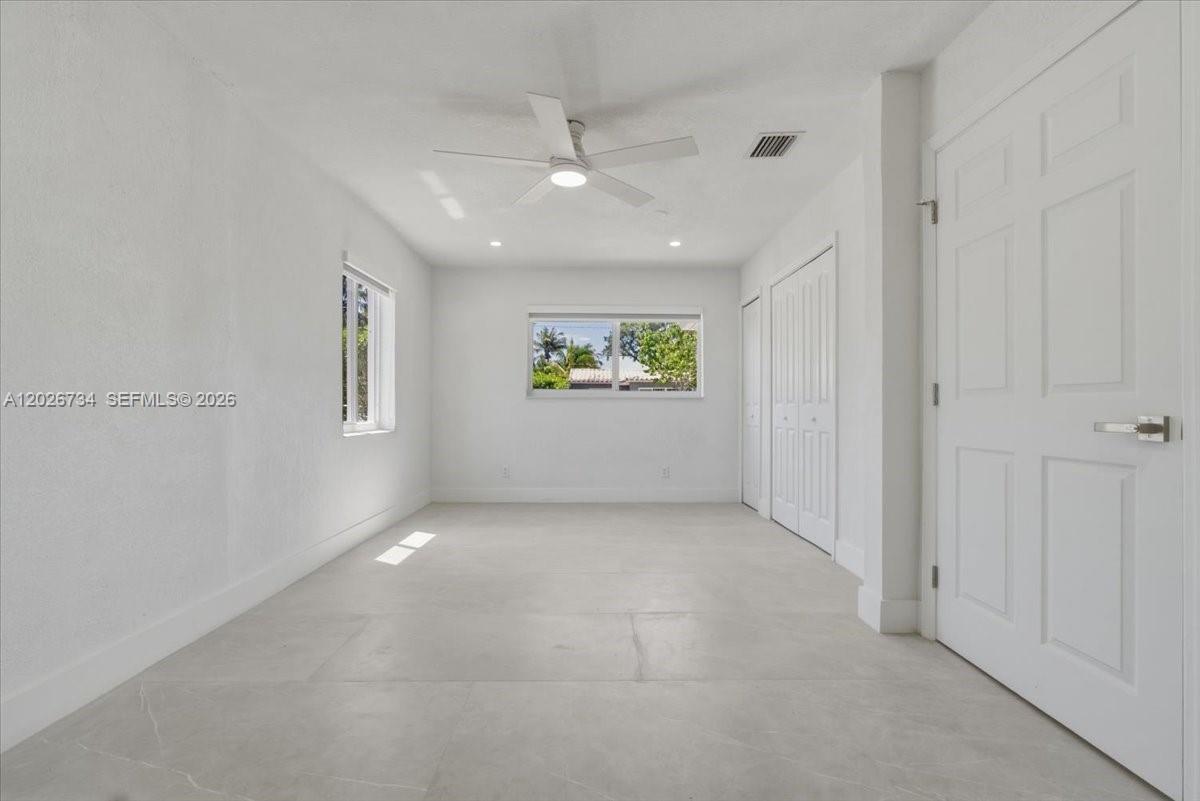 266 Southwest 6th Street Dania Beach, FL 33004 - Photo 11 of 37 an empty room with windows and ceiling fan