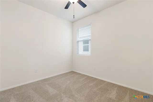 an empty room with a chandelier fan