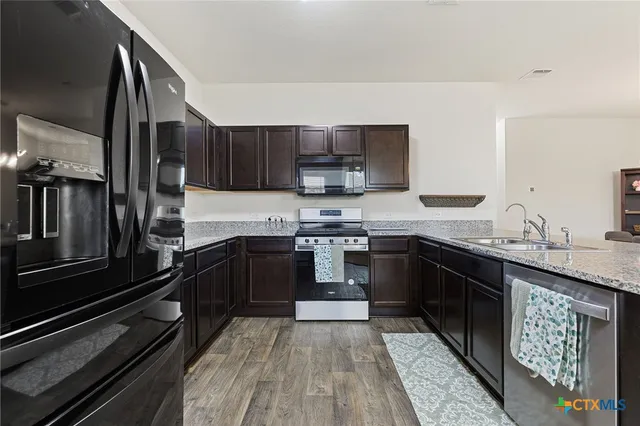 a kitchen with granite countertop stainless steel appliances and wooden cabinets
