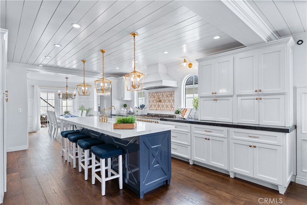 208 Indianapolis Avenue Huntington Beach, CA 92648 - Photo 11 of 66 a kitchen with granite countertop a table chairs sink and wooden floor