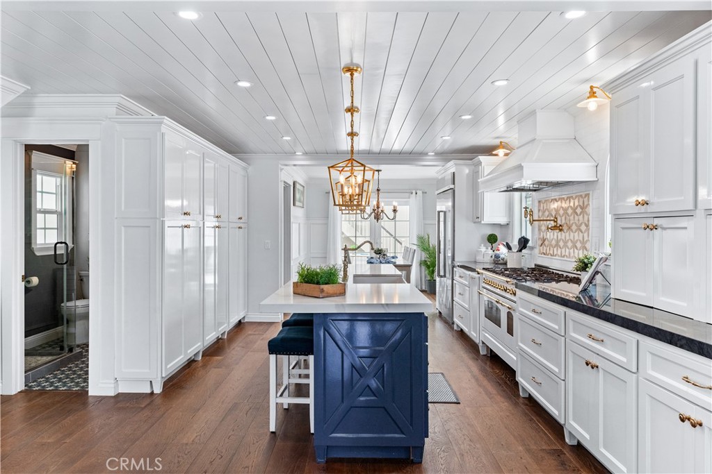 208 Indianapolis Avenue Huntington Beach, CA 92648 - Photo 12 of 66 a large kitchen with lots of counter space and wooden floor