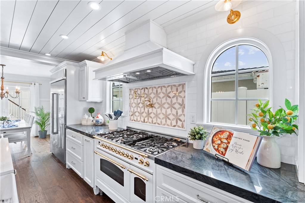 208 Indianapolis Avenue Huntington Beach, CA 92648 - Photo 17 of 66 a kitchen with stainless steel appliances a stove a chimney a sink and cabinets