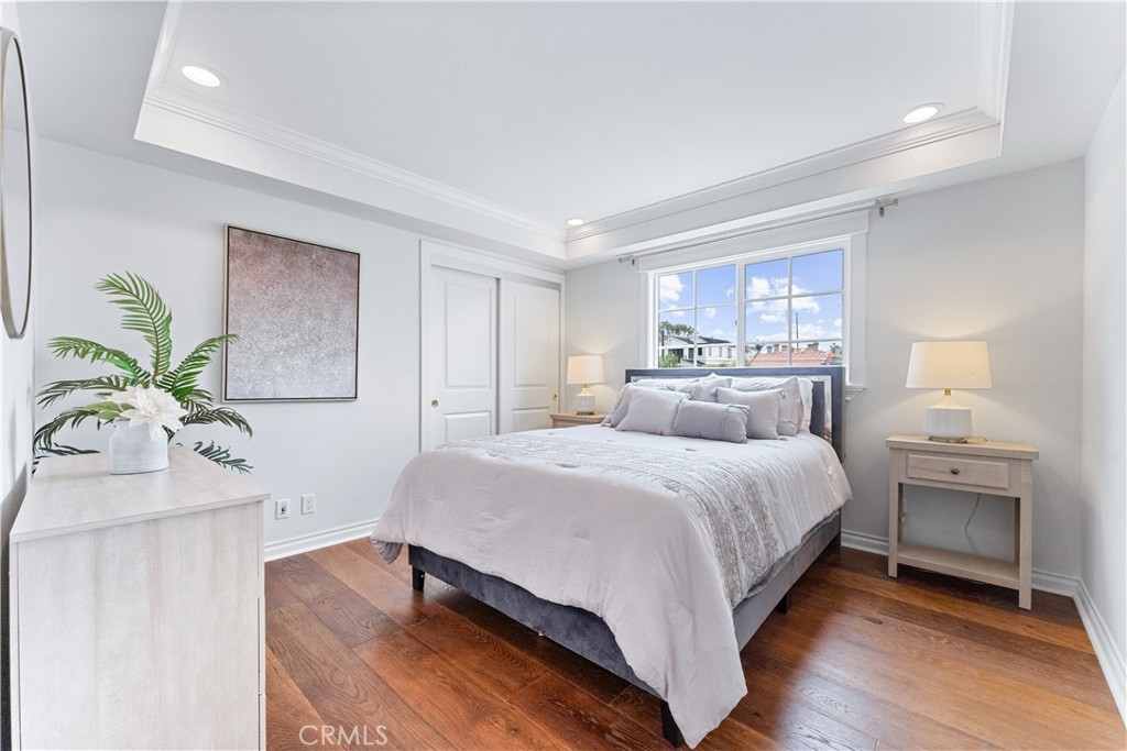 208 Indianapolis Avenue Huntington Beach, CA 92648 - Photo 28 of 66 a bedroom with a bed and a chandelier