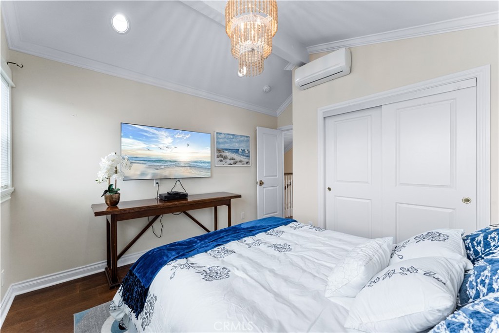 208 Indianapolis Avenue Huntington Beach, CA 92648 - Photo 43 of 66 a bedroom with a bed and a chandelier