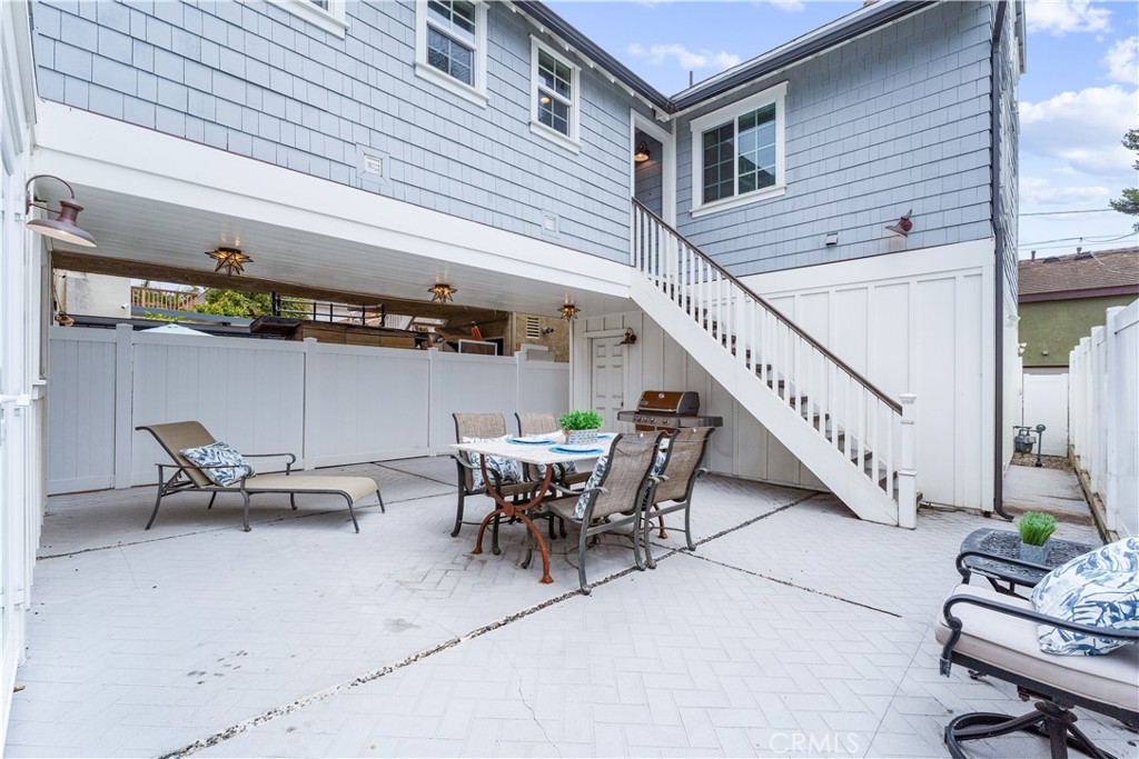 208 Indianapolis Avenue Huntington Beach, CA 92648 - Photo 46 of 66 a view of a patio with table and chairs and wooden floor