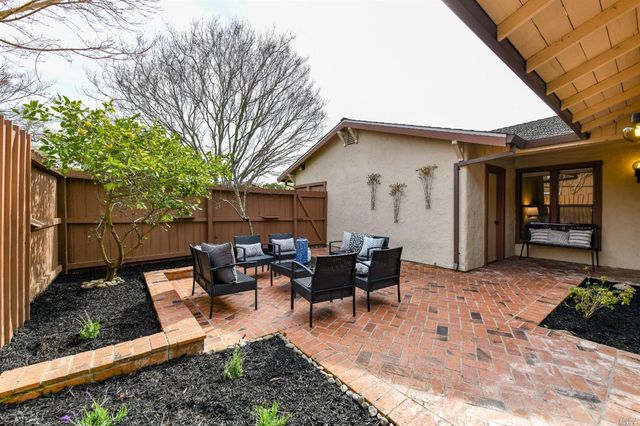 a view of a house with backyard and sitting area