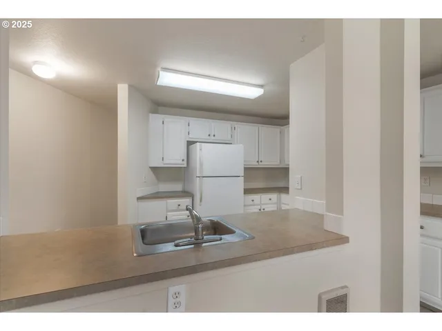 a kitchen with kitchen island a sink a stove and refrigerator