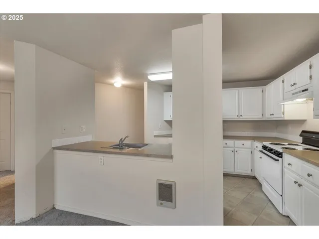 a kitchen with kitchen island a sink stainless steel appliances and cabinets