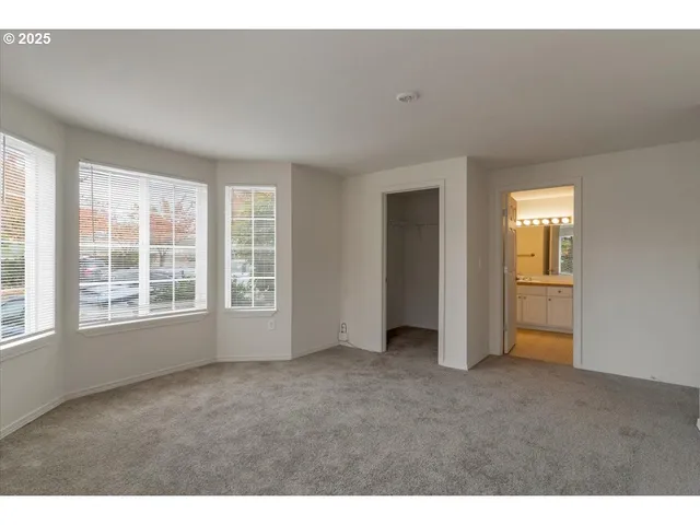 a bathroom with a toilet a sink a mirror a vanity and window