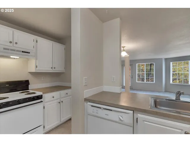 a kitchen with granite countertop a sink cabinets and window