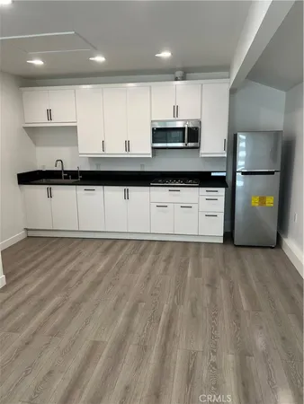 a kitchen with stainless steel appliances granite countertop a stove a sink and a refrigerator