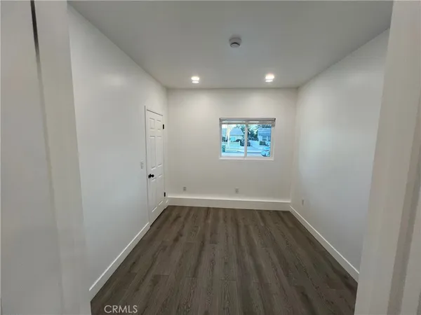 a view of hallway with wooden floor and a window