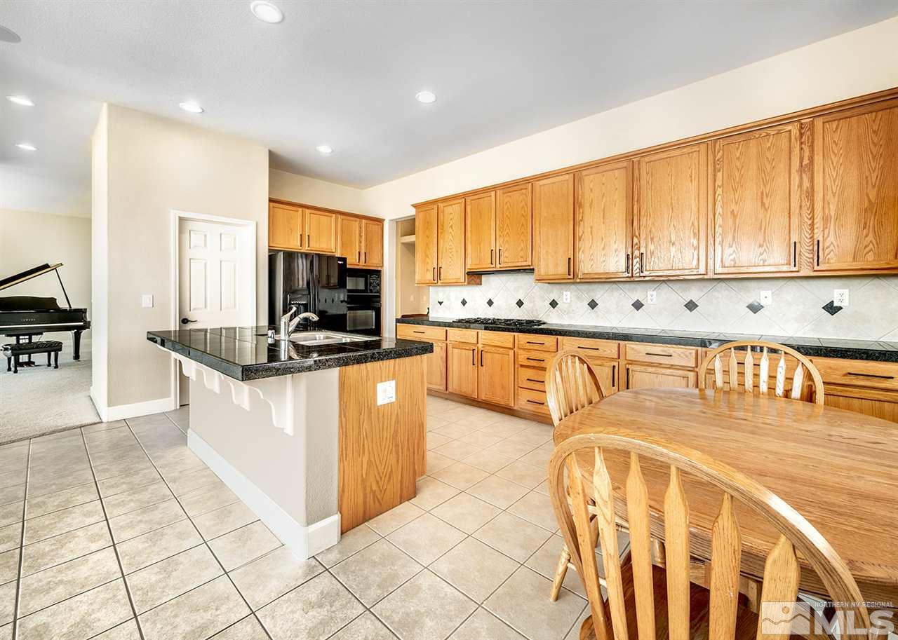 620 Rabbit Ridge Court Reno, NV 89511 - Photo 14 of 34 a kitchen with stainless steel appliances granite countertop a stove a sink and a microwave