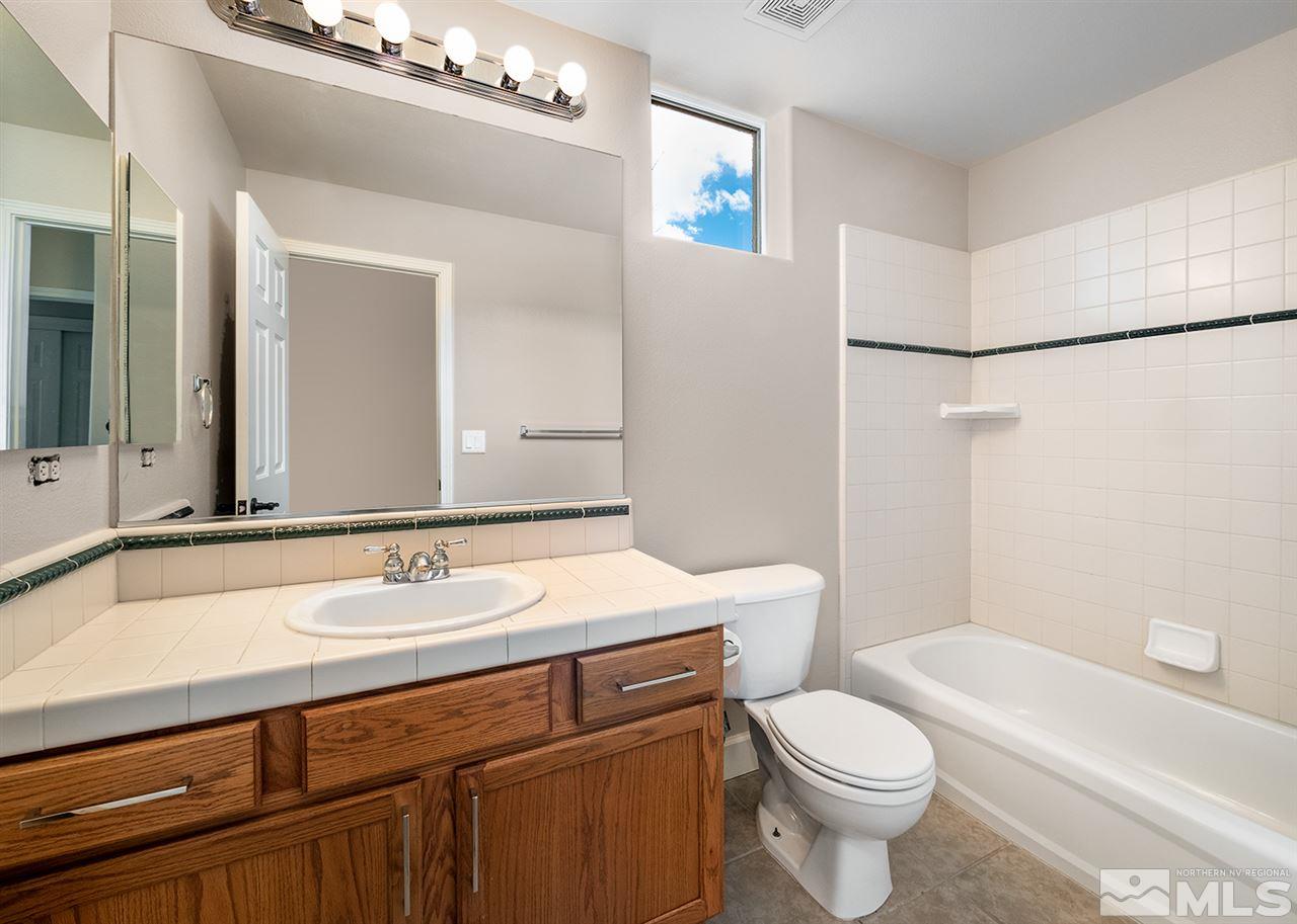620 Rabbit Ridge Court Reno, NV 89511 - Photo 24 of 34 a bathroom with a sink a toilet a mirror and shower