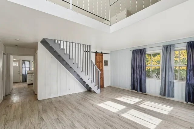 a view of a hallway with wooden floor and entryway