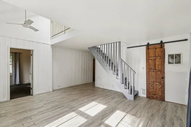 a view of a hallway with wooden floor and entryway